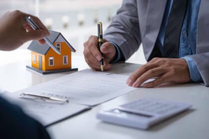 Dos personas durante la firma de un contrato en una oficina. La imagen representa una instancia de acuerdo formal entre partes y trámites vinculados a relaciones comerciales o legales.