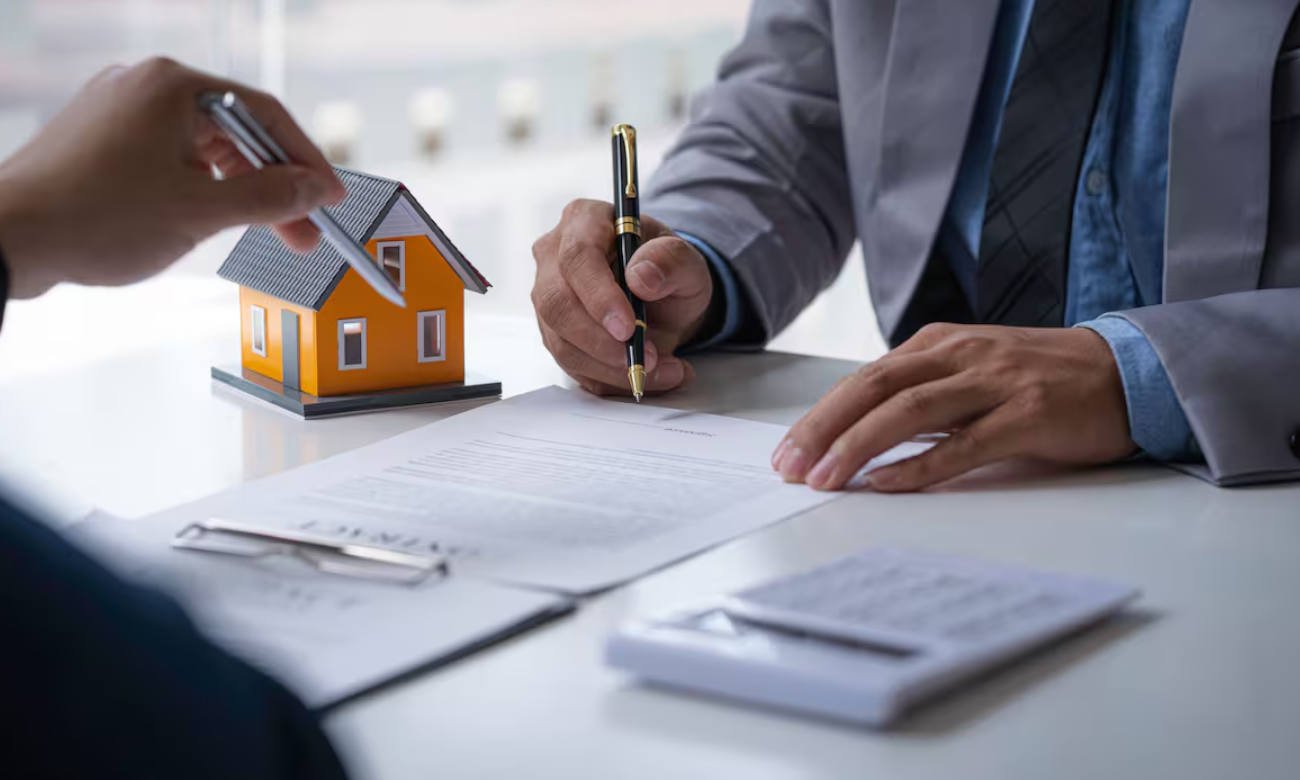 Dos personas durante la firma de un contrato en una oficina. La imagen representa una instancia de acuerdo formal entre partes y trámites vinculados a relaciones comerciales o legales.