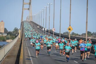 Leyenda atemporal de foto: Corredores atraviesan el puente Rosario-Victoria durante una nueva edición de la tradicional competencia deportiva.