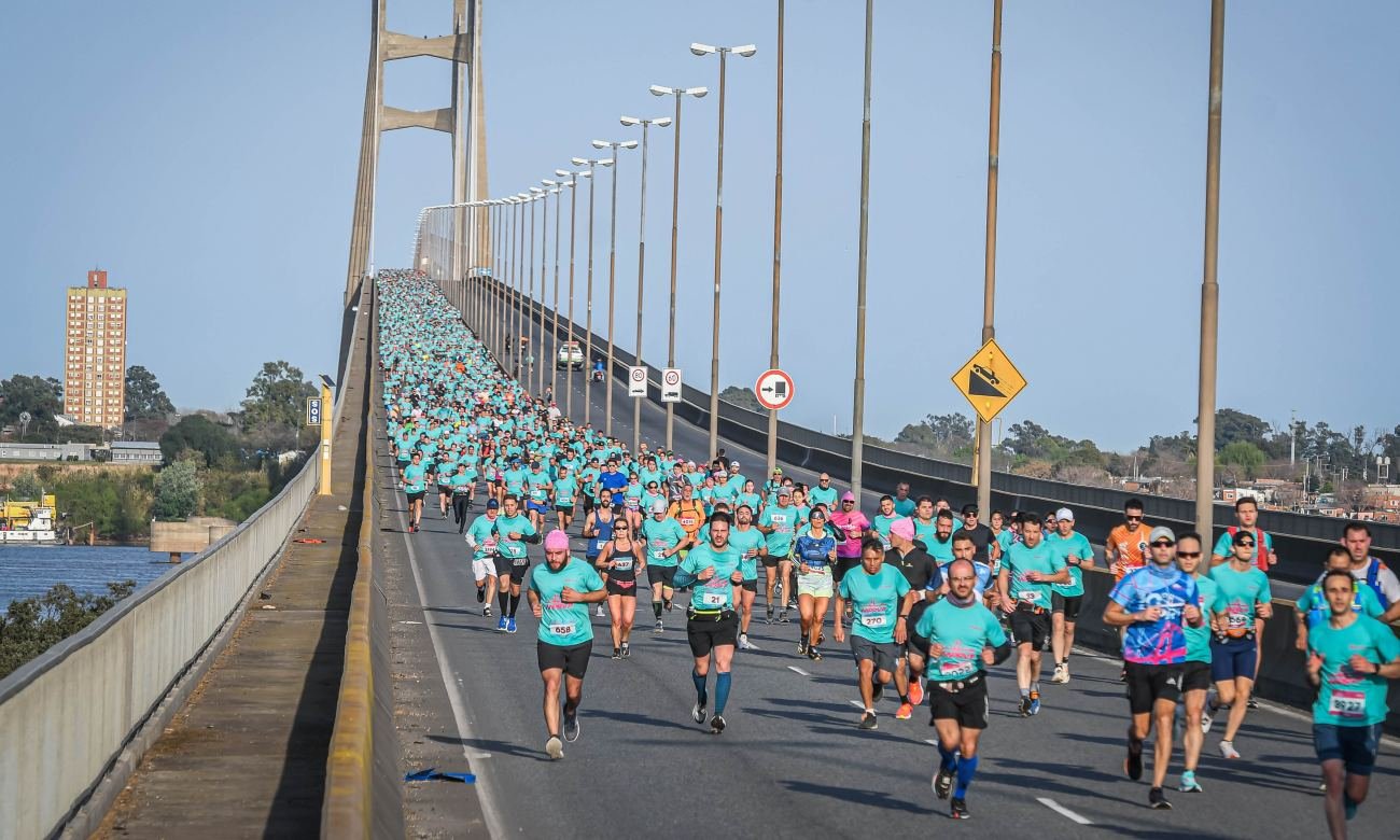Leyenda atemporal de foto: Corredores atraviesan el puente Rosario-Victoria durante una nueva edición de la tradicional competencia deportiva.