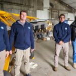 Rodrigo Borla junto a integrantes del Aero Club de Gobernador Crespo, durante la entrega de un aporte para la restauración de la aeronave de la institución.