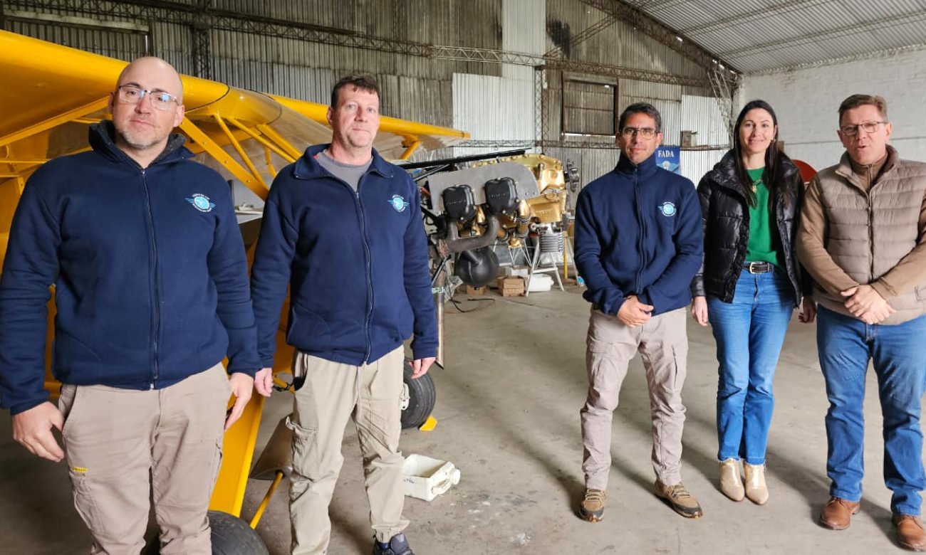 Rodrigo Borla junto a integrantes del Aero Club de Gobernador Crespo, durante la entrega de un aporte para la restauración de la aeronave de la institución.