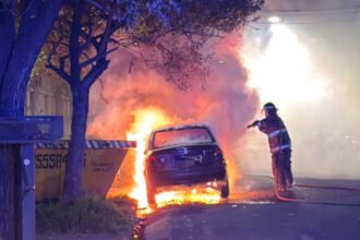 Bomberos trabajan en el lugar tras el incendio intencional de un vehículo estacionado en Barrio Sur.