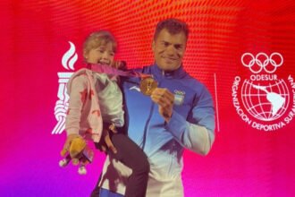 Rubén Rezola celebra junto a su hija y la medalla de oro conseguida en el K4 500 metros de los Juegos Suramericanos Santa Fe 2026.