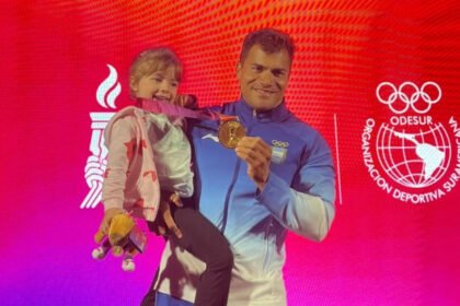 Rubén Rezola celebra junto a su hija y la medalla de oro conseguida en el K4 500 metros de los Juegos Suramericanos Santa Fe 2026.