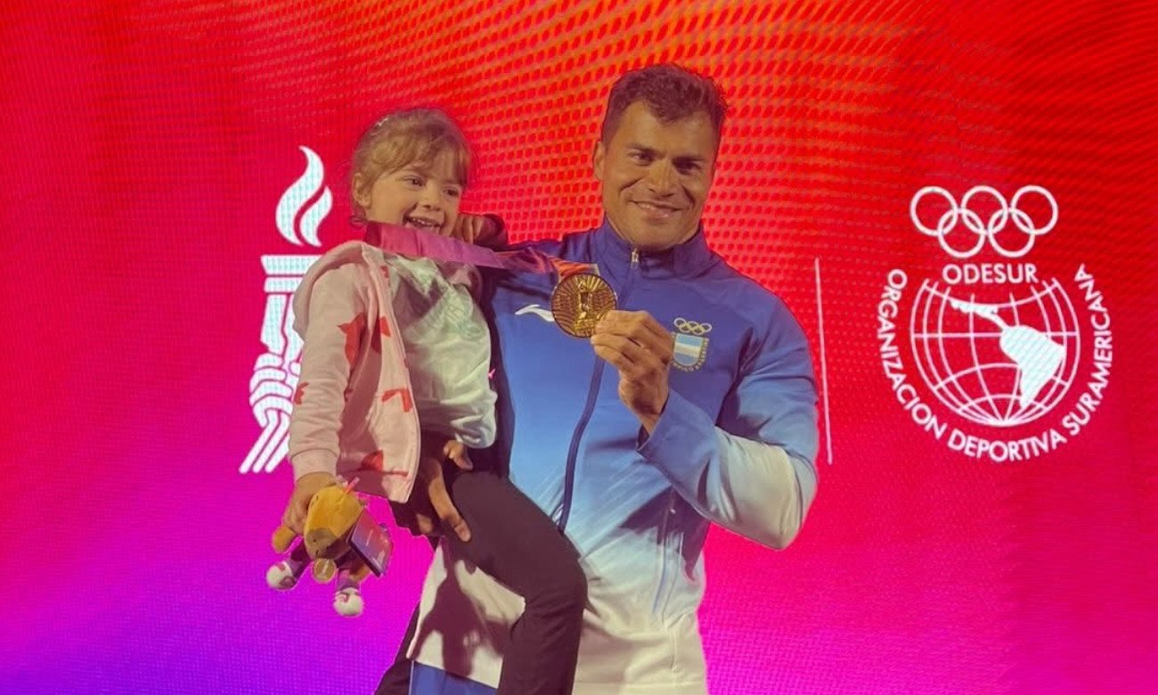 Rubén Rezola celebra junto a su hija y la medalla de oro conseguida en el K4 500 metros de los Juegos Suramericanos Santa Fe 2026.